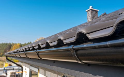 a-metal-black-gutter-on-a-roof-covered-with-ceramic-tiles-close-up-shot-roof-gutter-gutter-roofing_t20_6m0E4O